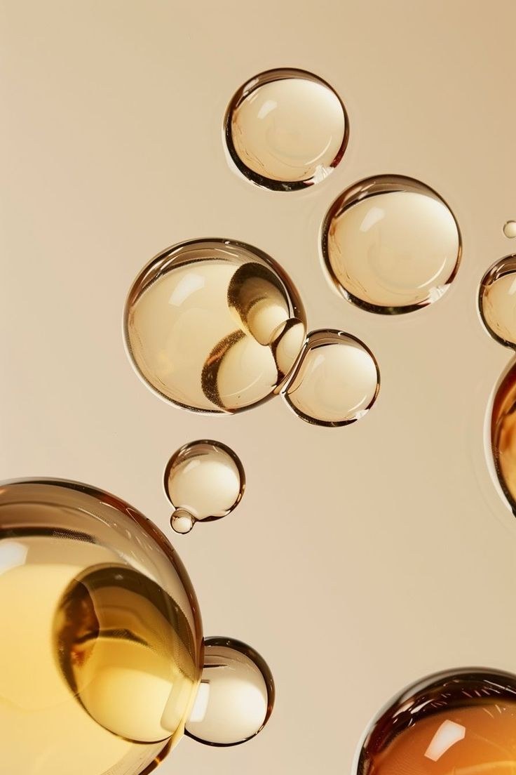 Golden serum droplets on a sand background